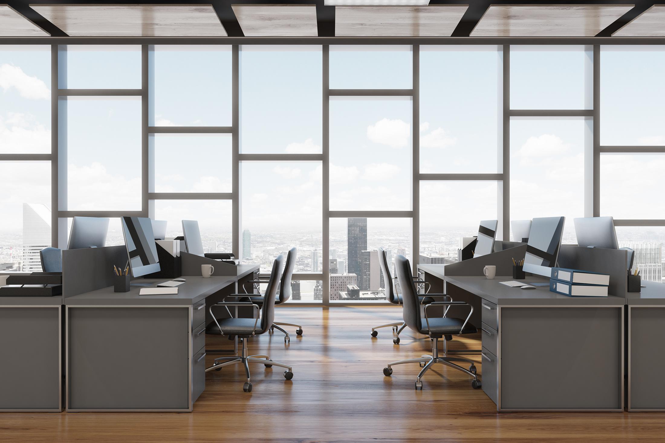 Shot of a communal office in a highrise with a glass window and a view of the city